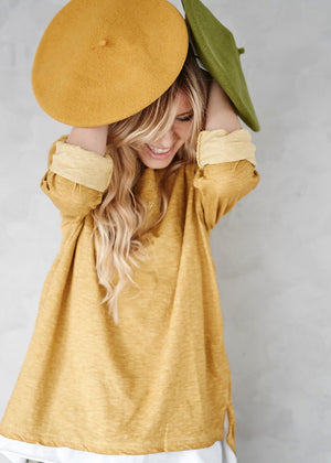 A person having a yellow and a green wool beret 