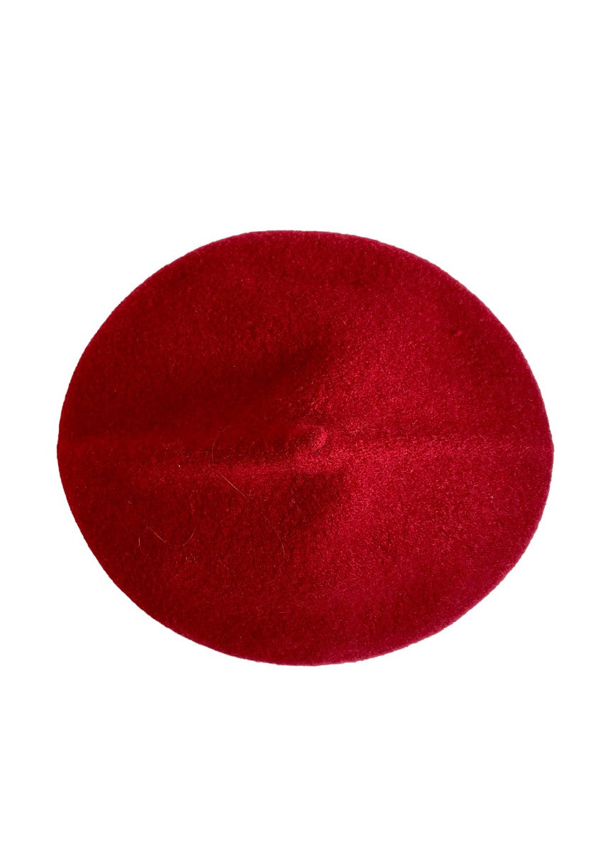 A red wool conical beret on a white background 